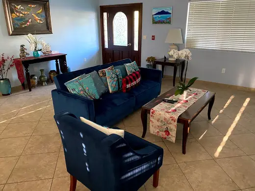 Bright living room with blue sofas at Coast Recovery Sober Living Homes & Outpatient Treatment Center, sober living home in Los Angeles.