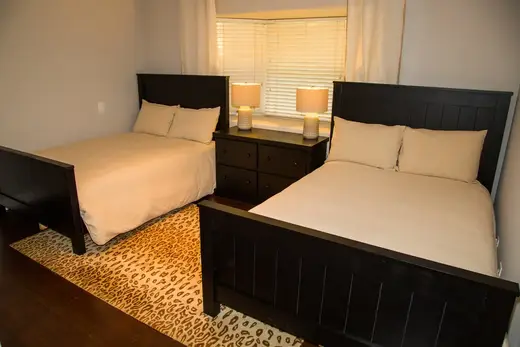 Cozy bedroom with two beds at Rewrite Recovery LLC, a sober living home in Los Angeles.